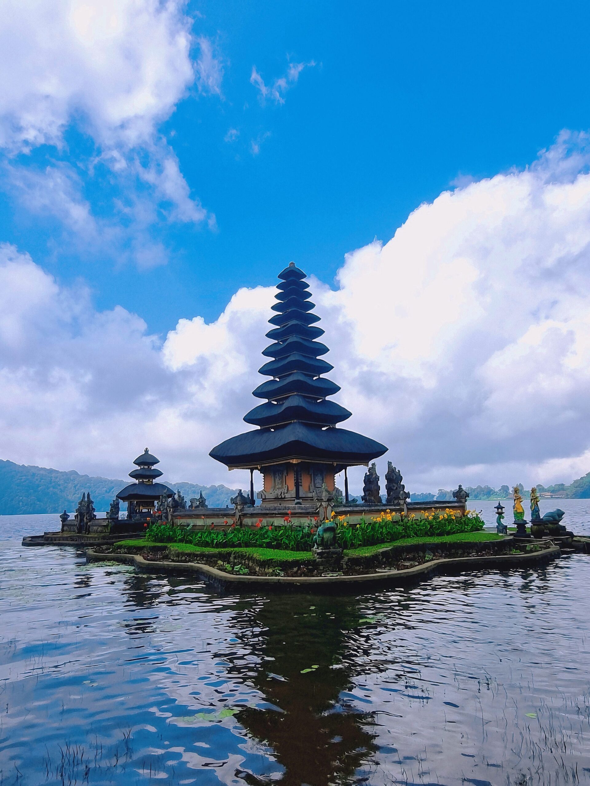 Ulun Danu Beratan Temple reflecting on Lake Beratan with a vibrant sky in Bali, Indonesia.