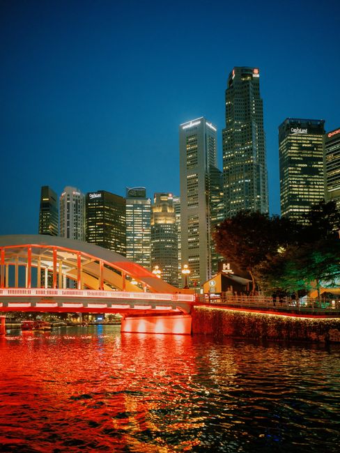 Stunning view of Singapore skyline with vibrant lights reflecting in the water at night.