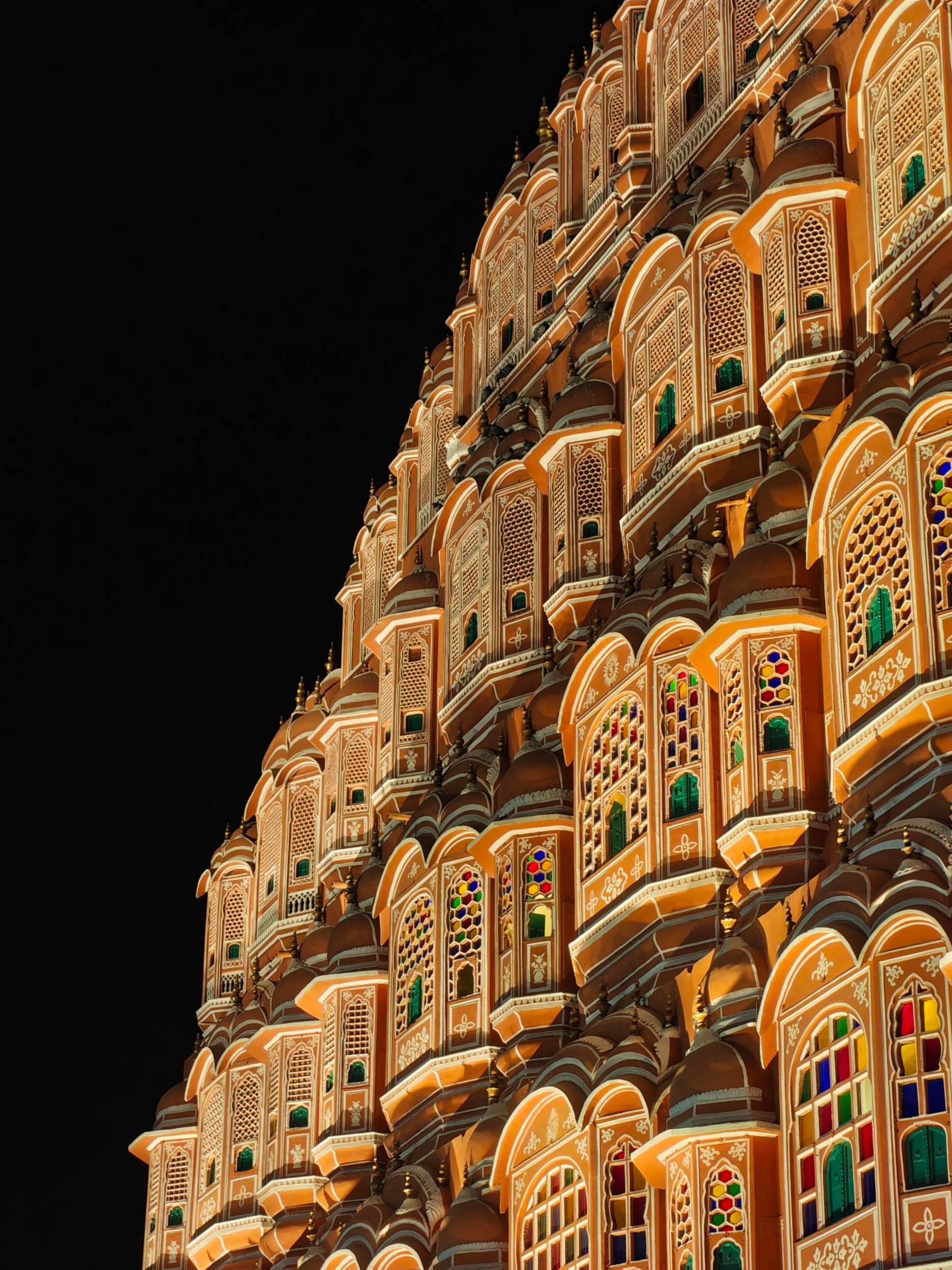 Detailed night view of Hawa Mahal's intricate facade in Jaipur, India.